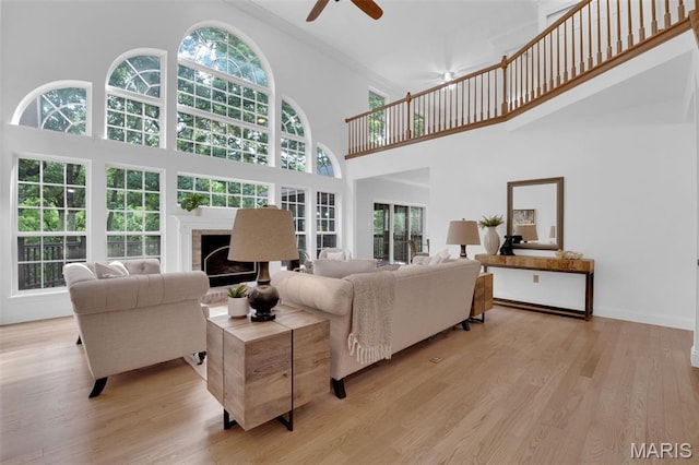 408 Bluff Meadow Dr, Ellisville, MO 63021 - living area with a towering ceiling, a fireplace, a ceiling fan, light wood-style floors, and crown molding