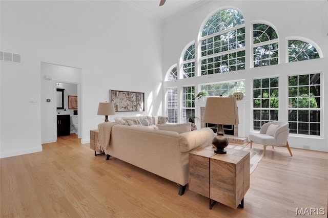 408 Bluff Meadow Dr, Ellisville, MO 63021 - living area featuring a towering ceiling, light wood-style floors, ornamental molding, and a ceiling fan