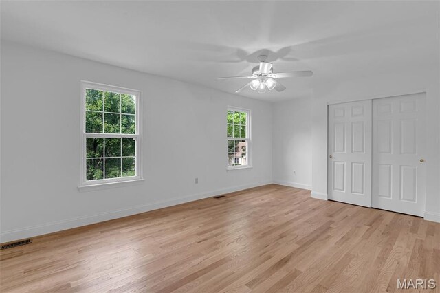 408 Bluff Meadow Dr, Ellisville, MO 63021 - unfurnished bedroom featuring multiple windows, light wood finished floors, a closet, and ceiling fan