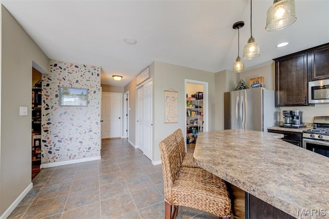 606 Wyndview Dr, Lake St Louis, MO 63367 - kitchen with stainless steel appliances, dark brown cabinetry, hanging light fixtures, and a breakfast bar