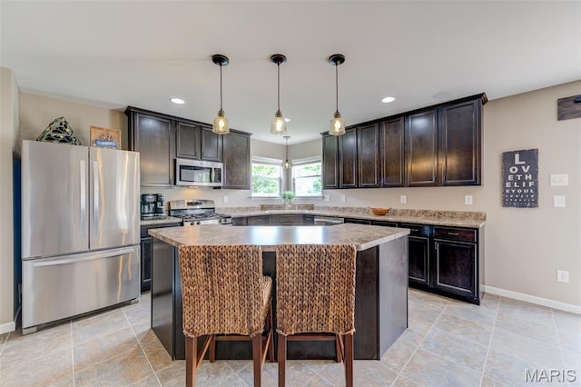 606 Wyndview Dr, Lake St Louis, MO 63367 - kitchen featuring appliances with stainless steel finishes, a kitchen island, recessed lighting, dark brown cabinets, and pendant lighting