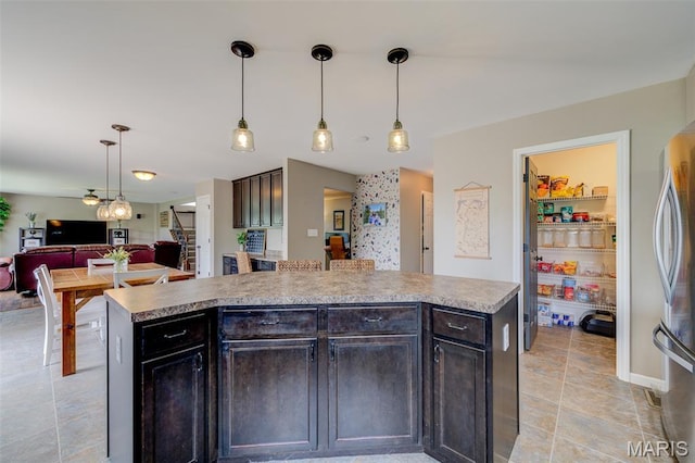 606 Wyndview Dr, Lake St Louis, MO 63367 - kitchen featuring freestanding refrigerator, open floor plan, light countertops, hanging light fixtures, and dark brown cabinetry