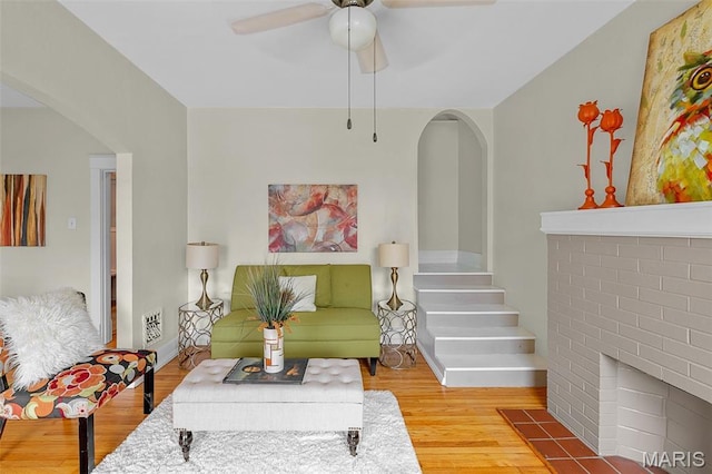 3119 Tamm Ave, Saint Louis, MO 63139 - living area featuring arched walkways, ceiling fan, wood finished floors, and stairs
