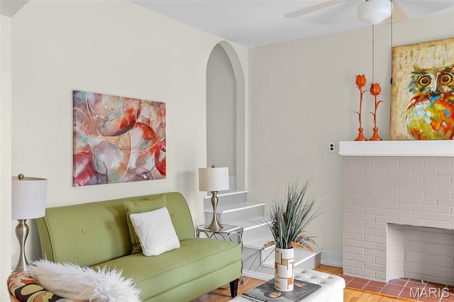 3119 Tamm Ave, Saint Louis, MO 63139 - living area featuring wood finished floors, a ceiling fan, arched walkways, and a brick fireplace