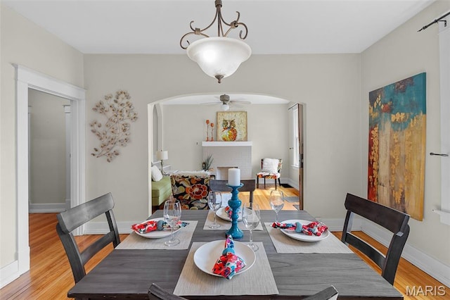 3119 Tamm Ave, Saint Louis, MO 63139 - dining area with arched walkways, light wood-style flooring, and a ceiling fan