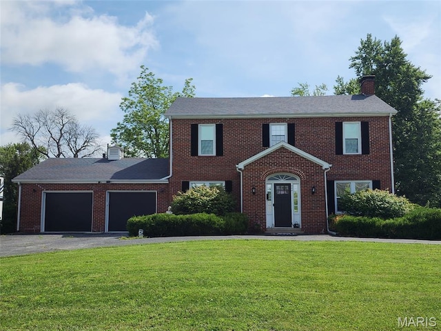 402 S Walker St, Montgomery City, MO 63361 - view of front of house featuring a chimney, an attached garage, a front lawn, asphalt driveway, and brick siding