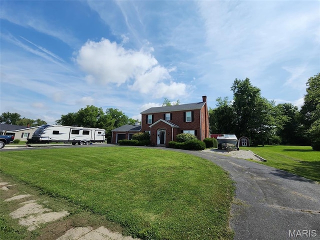 402 S Walker St, Montgomery City, MO 63361 - view of front of home featuring brick siding, a front lawn, a chimney, asphalt driveway, and a garage