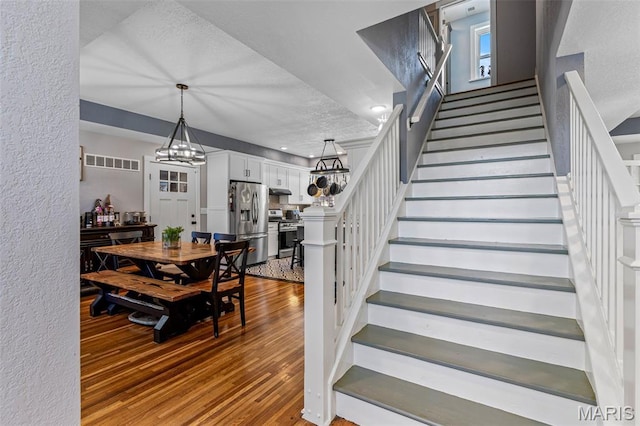 402 S Walker St, Montgomery City, MO 63361 - dining area featuring stairway, wood finished floors, a textured ceiling, and a chandelier