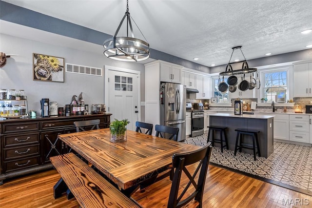 402 S Walker St, Montgomery City, MO 63361 - dining area with wood finished floors, recessed lighting, a textured ceiling, and a chandelier