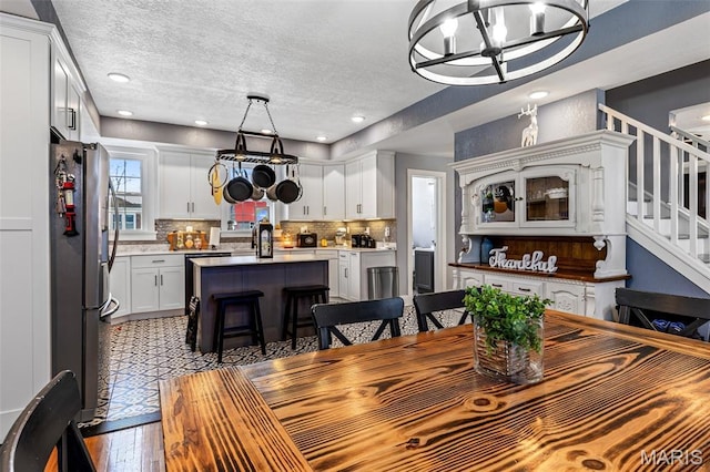 402 S Walker St, Montgomery City, MO 63361 - dining area with a chandelier, stairs, a textured ceiling, wood finished floors, and recessed lighting