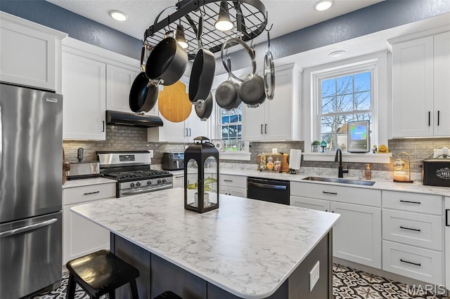 402 S Walker St, Montgomery City, MO 63361 - kitchen with appliances with stainless steel finishes, a kitchen breakfast bar, a kitchen island, tasteful backsplash, and white cabinetry