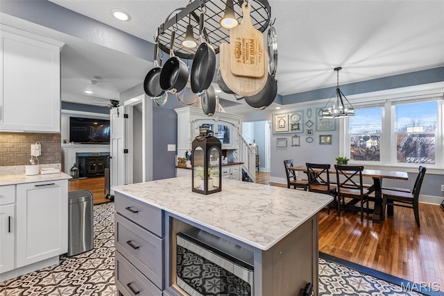 402 S Walker St, Montgomery City, MO 63361 - kitchen featuring backsplash, stainless steel microwave, white cabinetry, light stone counters, and recessed lighting