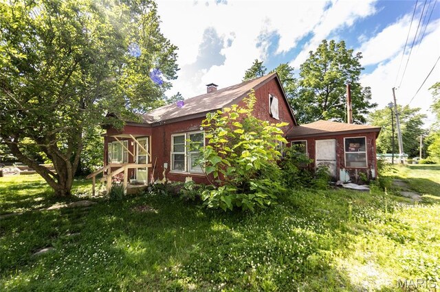 129 Maple Ave, Licking, MO 65542 - view of side of property featuring a sunroom, a lawn, and a chimney
