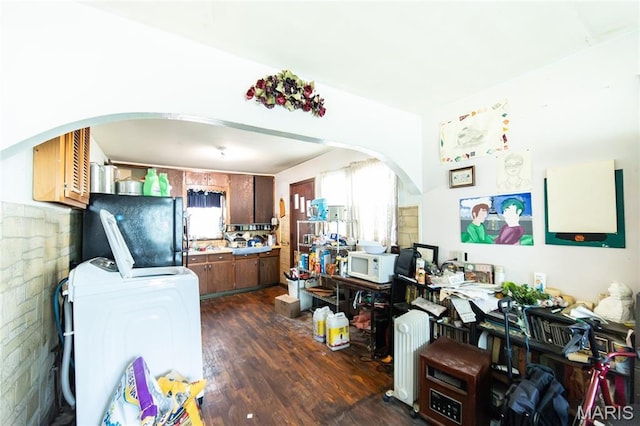 129 Maple Ave, Licking, MO 65542 - kitchen with arched walkways, fridge, dark wood-style floors, white microwave, and light countertops