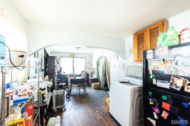 129 Maple Ave, Licking, MO 65542 - kitchen featuring arched walkways, washer / dryer, freestanding refrigerator, brown cabinets, and dark wood-style flooring