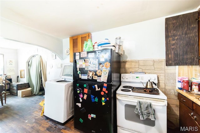 129 Maple Ave, Licking, MO 65542 - kitchen with white electric stove, freestanding refrigerator, washer / dryer, dark wood-style floors, and arched walkways