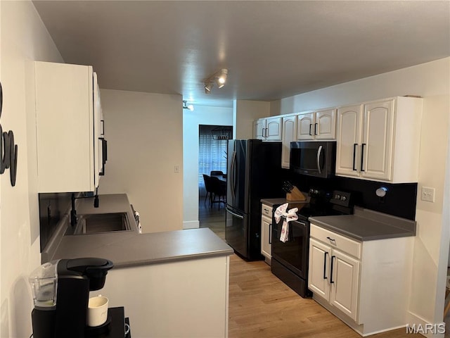740 Shadow Pine Dr, Fenton, MO 63026 - kitchen featuring black appliances, light wood-style floors, white cabinets, and dark countertops