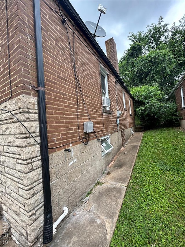 7155 Theodore Ave, Jennings, MO 63136 - view of home's exterior with brick siding, a chimney, cooling unit, and a lawn