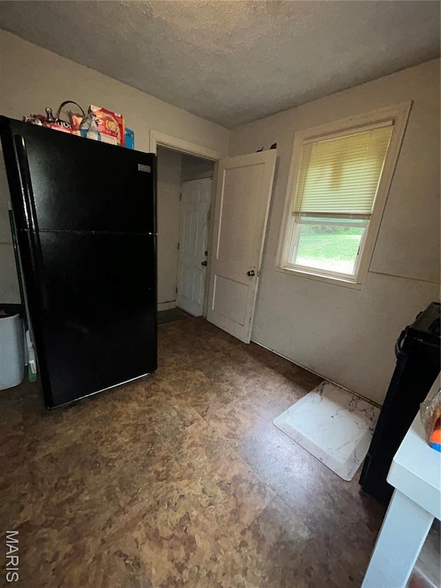 7155 Theodore Ave, Jennings, MO 63136 - interior space featuring freestanding refrigerator and a textured ceiling