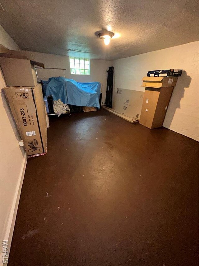 7155 Theodore Ave, Jennings, MO 63136 - unfurnished bedroom with a textured ceiling and concrete floors
