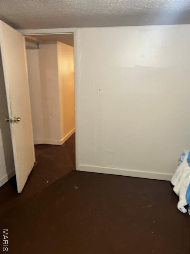 7155 Theodore Ave, Jennings, MO 63136 - unfurnished bedroom with a textured ceiling and baseboards