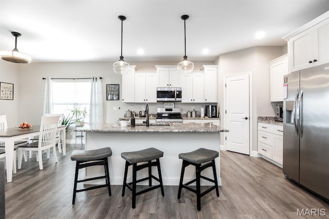 812 Green Jacket Way, Ofallon, IL 62269 - kitchen with stainless steel appliances, wood finished floors, white cabinets, a kitchen breakfast bar, and recessed lighting