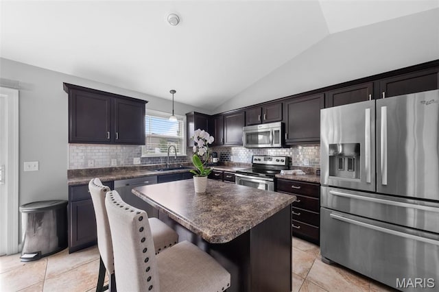80 Brookshire Creek Dr, Wentzville, MO 63385 - kitchen featuring appliances with stainless steel finishes, vaulted ceiling, dark countertops, backsplash, and a kitchen bar