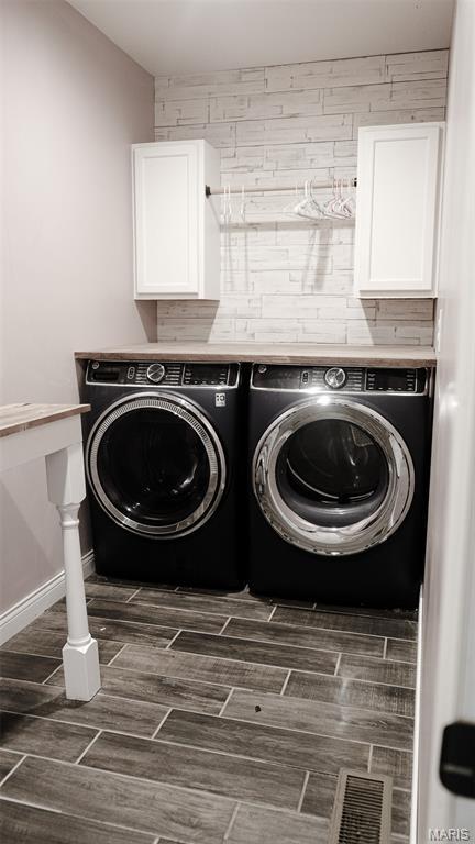 3215 Timber Ridge Rd, Palmyra, MO 63461 - laundry room featuring independent washer and dryer, wood finish floors, and cabinet space