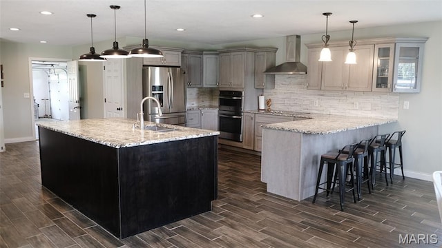 3215 Timber Ridge Rd, Palmyra, MO 63461 - kitchen with wall chimney range hood, appliances with stainless steel finishes, wood finish floors, decorative backsplash, and recessed lighting