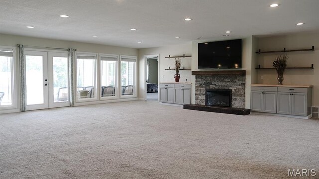 3215 Timber Ridge Rd, Palmyra, MO 63461 - unfurnished living room with carpet flooring, recessed lighting, a stone fireplace, and french doors