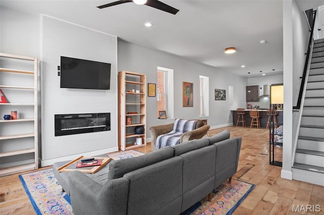 3452 Osage St, Saint Louis, MO 63118 - living area with stairway, recessed lighting, ceiling fan, light wood-style floors, and a glass covered fireplace