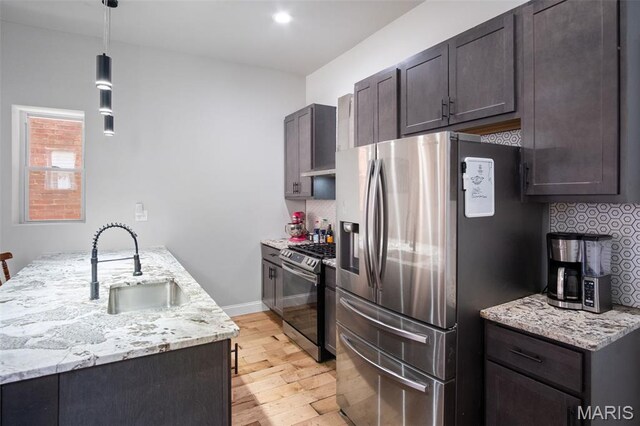 3452 Osage St, Saint Louis, MO 63118 - kitchen with stainless steel appliances, light wood-type flooring, backsplash, light stone counters, and dark brown cabinets