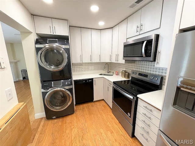 1418 Bluebird Ter, Saint Louis, MO 63144 - kitchen with stainless steel appliances, stacked washing machine and dryer, light wood-style flooring, light countertops, and recessed lighting