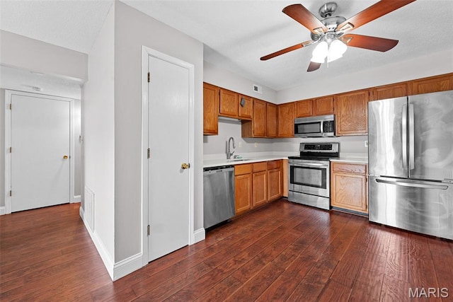 2 Berview Cir Unit H, Saint Louis, MO 63129 - kitchen featuring appliances with stainless steel finishes, light countertops, dark wood-style flooring, and a ceiling fan