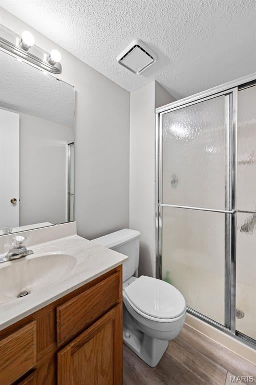 2 Berview Cir Unit H, Saint Louis, MO 63129 - bathroom with vanity, wood finished floors, a stall shower, and a textured ceiling