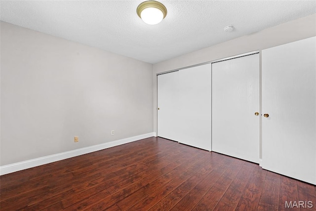 2 Berview Cir Unit H, Saint Louis, MO 63129 - unfurnished bedroom with wood-type flooring, a closet, and a textured ceiling