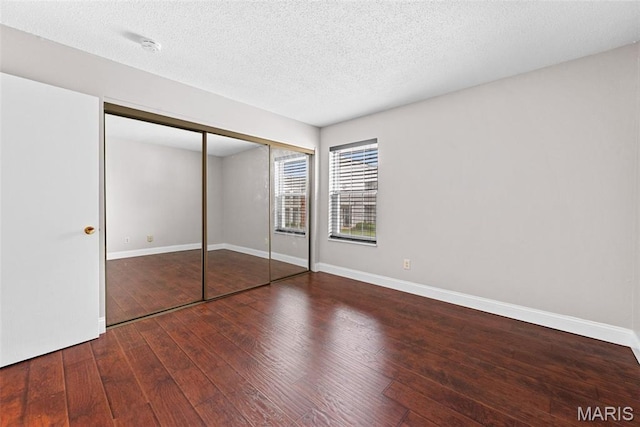2 Berview Cir Unit H, Saint Louis, MO 63129 - unfurnished bedroom with wood-type flooring, a closet, and a textured ceiling