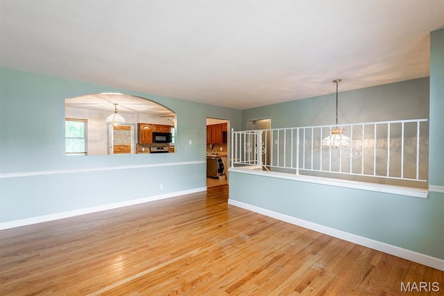 1907 Lone Pine Dr, Arnold, MO 63010 - unfurnished room featuring a chandelier, arched walkways, and light wood-style floors