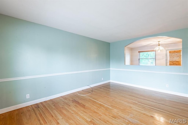 1907 Lone Pine Dr, Arnold, MO 63010 - unfurnished room with a chandelier, wood finished floors, and arched walkways
