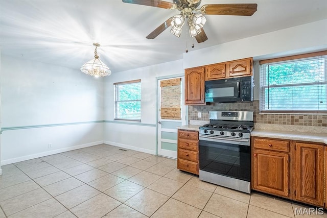 1907 Lone Pine Dr, Arnold, MO 63010 - kitchen featuring black microwave, gas stove, light countertops, backsplash, and brown cabinetry