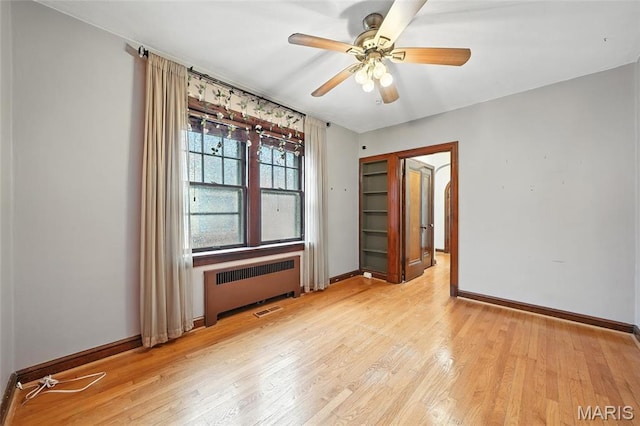 5743 Delor St, Saint Louis, MO 63109 - spare room featuring radiator, light wood finished floors, and a ceiling fan