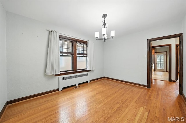 5743 Delor St, Saint Louis, MO 63109 - unfurnished room featuring radiator, a chandelier, and light wood-style floors