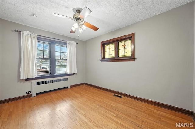 5743 Delor St, Saint Louis, MO 63109 - empty room featuring radiator, hardwood / wood-style floors, a textured ceiling, and ceiling fan