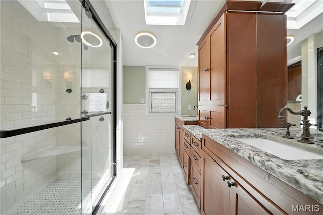 5743 Delor St, Saint Louis, MO 63109 - full bath with a stall shower, vanity, tile walls, marble finish flooring, and a wainscoted wall