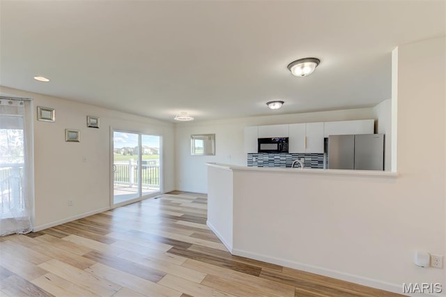 502 Summer Glen Ln, Saint Charles, MO 63301 - kitchen featuring black microwave, freestanding refrigerator, light wood finished floors, white cabinets, and recessed lighting