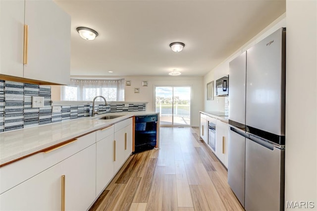 502 Summer Glen Ln, Saint Charles, MO 63301 - kitchen with appliances with stainless steel finishes, white cabinetry, light wood-type flooring, light countertops, and decorative backsplash