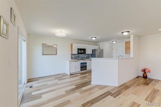 502 Summer Glen Ln, Saint Charles, MO 63301 - kitchen with black appliances, light wood finished floors, decorative backsplash, white cabinets, and light countertops