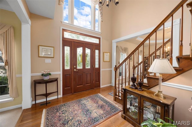 16368 Cherry Orchard Dr, Grover, MO 63040 - foyer featuring stairway, a chandelier, wood finished floors, and a high ceiling