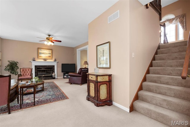 16368 Cherry Orchard Dr, Grover, MO 63040 - carpeted living area featuring stairway, ceiling fan, and a fireplace with flush hearth