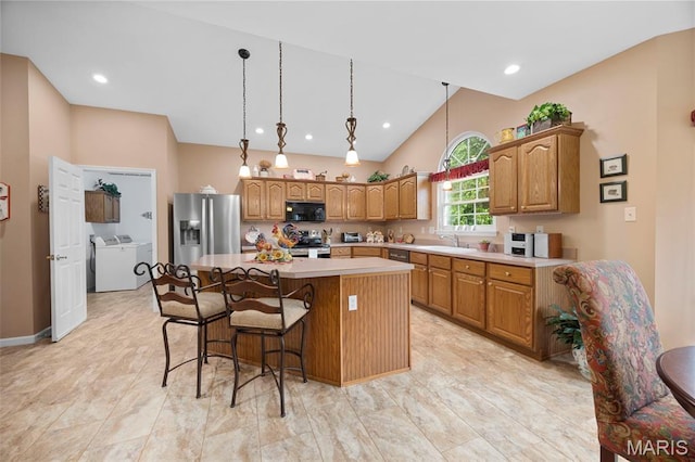 16368 Cherry Orchard Dr, Grover, MO 63040 - kitchen with appliances with stainless steel finishes, a kitchen island, light countertops, a kitchen breakfast bar, and lofted ceiling